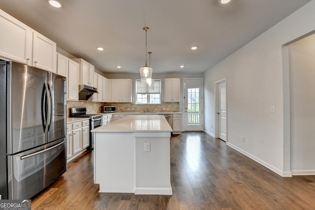 3360 Pickens St, Duluth, GA 30096 - kitchen featuring appliances with stainless steel finishes, under cabinet range hood, light countertops, backsplash, and dark wood-type flooring