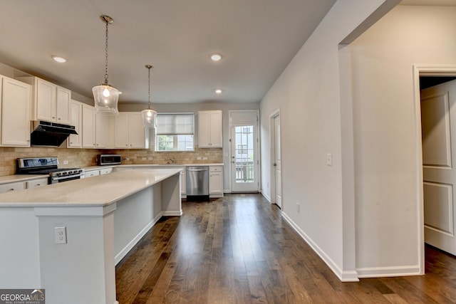 3360 Pickens St, Duluth, GA 30096 - kitchen with appliances with stainless steel finishes, under cabinet range hood, light countertops, tasteful backsplash, and dark wood finished floors