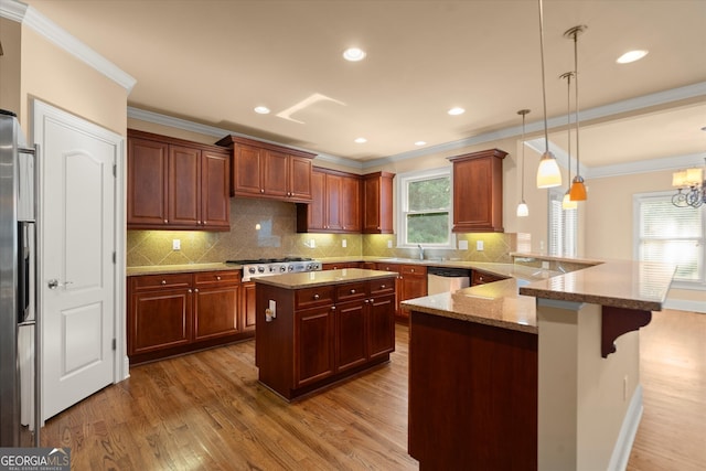 10565 Highgate Manor Ct, Duluth, GA 30097 - kitchen with wood finished floors, stainless steel appliances, a peninsula, ornamental molding, and light stone countertops