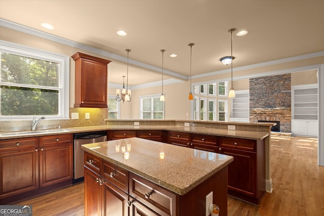10565 Highgate Manor Ct, Duluth, GA 30097 - kitchen featuring dishwasher, a center island, a sink, a fireplace, and wood finished floors