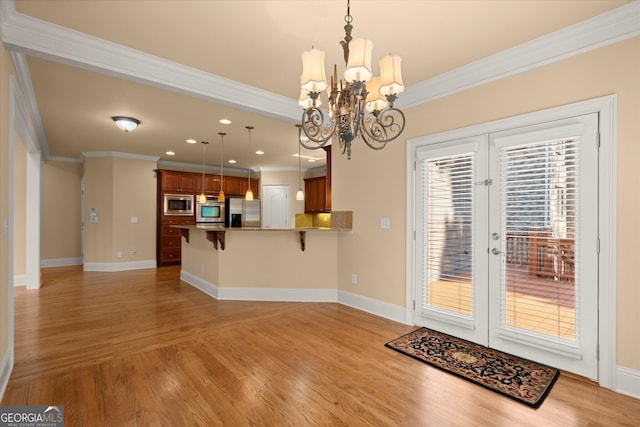 10565 Highgate Manor Ct, Duluth, GA 30097 - kitchen with stainless steel appliances, french doors, crown molding, a kitchen breakfast bar, and light wood-style flooring