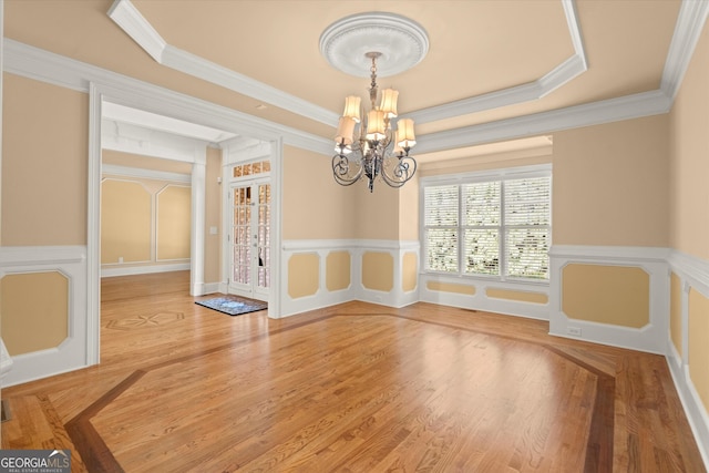 10565 Highgate Manor Ct, Duluth, GA 30097 - unfurnished dining area with a chandelier, ornamental molding, wood finished floors, a wainscoted wall, and a decorative wall
