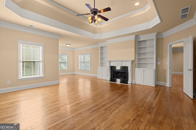 10565 Highgate Manor Ct, Duluth, GA 30097 - unfurnished living room with ceiling fan, a raised ceiling, light wood-type flooring, crown molding, and a fireplace