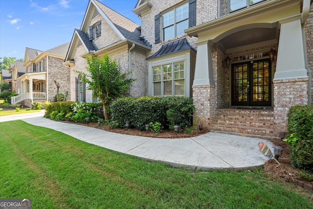 10565 Highgate Manor Ct, Duluth, GA 30097 - view of side of home with french doors, brick siding, a yard, and a standing seam roof
