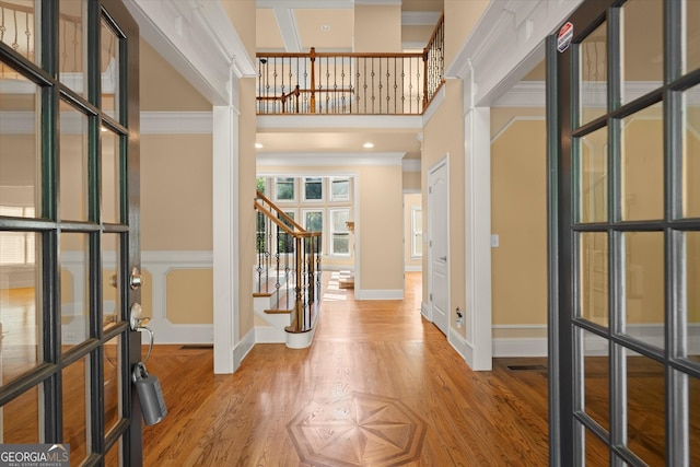 10565 Highgate Manor Ct, Duluth, GA 30097 - foyer entrance featuring stairway, a towering ceiling, light wood-type flooring, ornamental molding, and baseboards