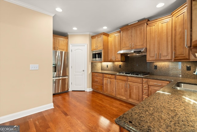 10565 Highgate Manor Ct, Duluth, GA 30097 - kitchen with stainless steel appliances, under cabinet range hood, crown molding, recessed lighting, and decorative backsplash