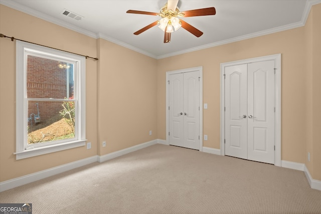 10565 Highgate Manor Ct, Duluth, GA 30097 - unfurnished bedroom with multiple closets, light carpet, ornamental molding, baseboards, and a ceiling fan