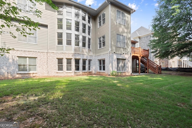10565 Highgate Manor Ct, Duluth, GA 30097 - rear view of property with stairway, brick siding, a deck, and a yard