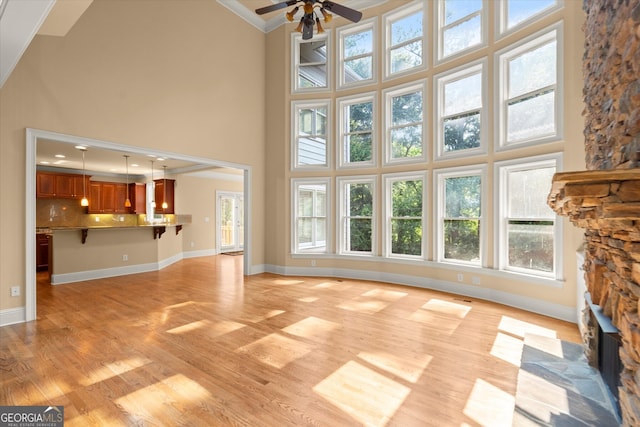 10565 Highgate Manor Ct, Duluth, GA 30097 - unfurnished living room with a high ceiling, ceiling fan, light wood-style flooring, ornamental molding, and healthy amount of natural light