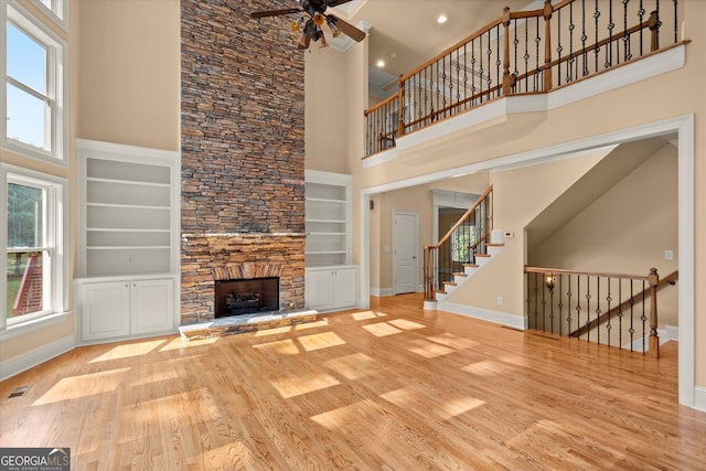 10565 Highgate Manor Ct, Duluth, GA 30097 - unfurnished living room featuring a towering ceiling, plenty of natural light, a ceiling fan, baseboards, and wood finished floors