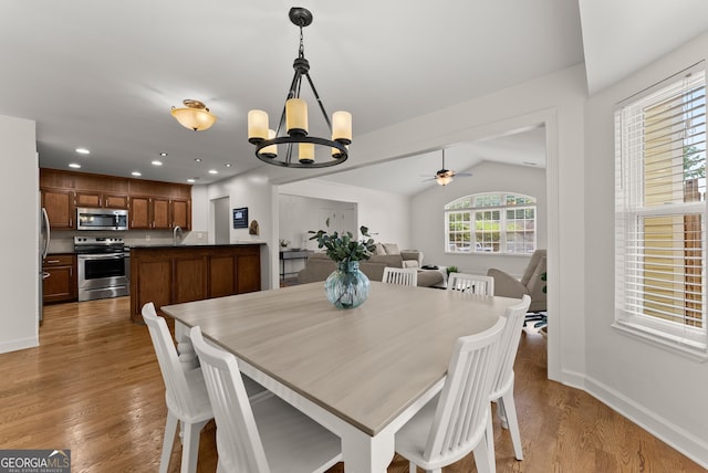 2605 Fort Apachee Trl, Dacula, GA 30019 - dining area featuring a chandelier, vaulted ceiling, wood finished floors, a ceiling fan, and baseboards