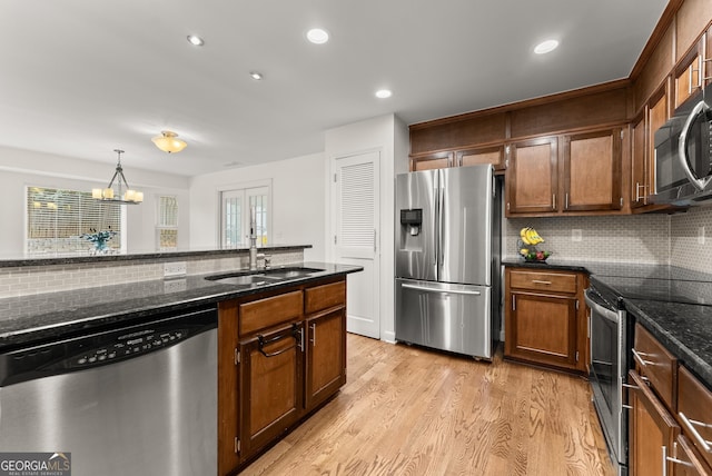 2605 Fort Apachee Trl, Dacula, GA 30019 - kitchen with appliances with stainless steel finishes, a sink, tasteful backsplash, light wood-type flooring, and dark stone counters