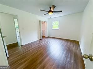 241 Sarann Ct NW, Lilburn, GA 30047 - unfurnished bedroom featuring wood finished floors, baseboards, and a ceiling fan