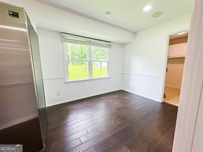 241 Sarann Ct NW, Lilburn, GA 30047 - unfurnished bedroom with wood finished floors, freestanding refrigerator, a walk in closet, and a closet
