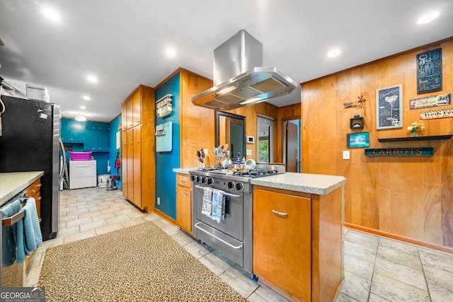 1138 Berkeley Rd, Avondale Estates, GA 30002 - kitchen featuring island exhaust hood, stainless steel appliances, wooden walls, light countertops, and brown cabinetry