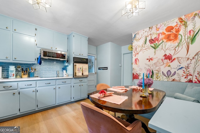 1138 Berkeley Rd, Avondale Estates, GA 30002 - kitchen with oven, blue cabinets, light wood-type flooring, and backsplash