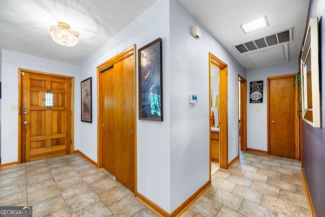 1138 Berkeley Rd, Avondale Estates, GA 30002 - entrance foyer with light stone finish floors, baseboards, and a chandelier