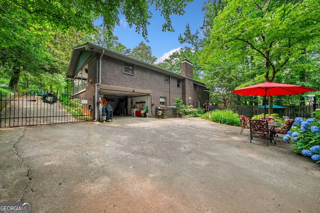 1138 Berkeley Rd, Avondale Estates, GA 30002 - view of home's exterior with brick siding, a chimney, and driveway