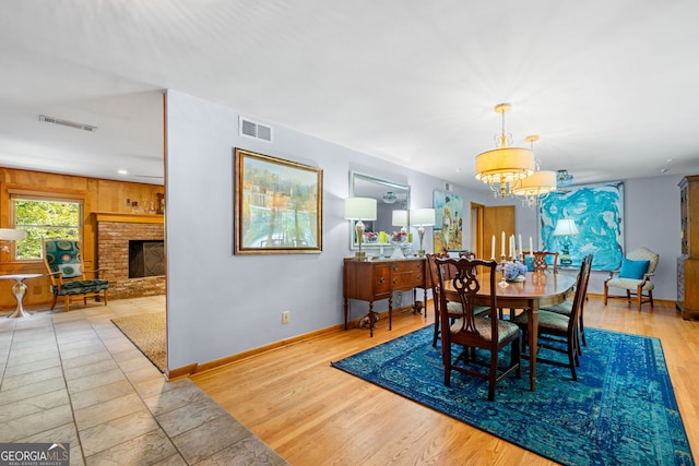 1138 Berkeley Rd, Avondale Estates, GA 30002 - dining area featuring a chandelier, baseboards, a brick fireplace, and wood finished floors
