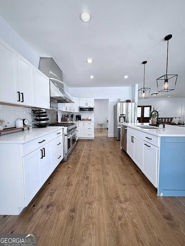 128 Golden Hills Dr, Woodstock, GA 30189 - kitchen with stainless steel appliances, a sink, dark wood-style flooring, decorative light fixtures, and tasteful backsplash