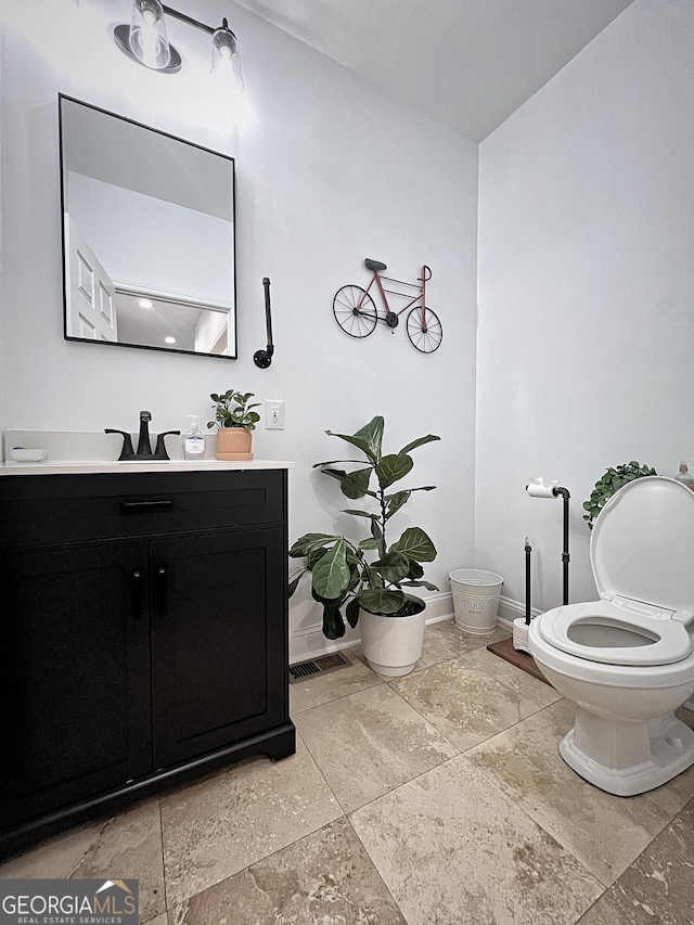 128 Golden Hills Dr, Woodstock, GA 30189 - half bathroom featuring vanity, toilet, baseboards, and stone tile floors