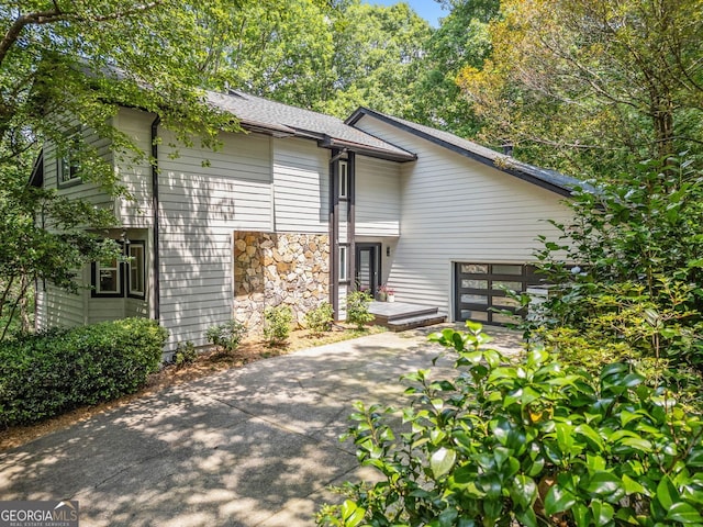 545 Matterhorn Way, Alpharetta, GA 30022 - view of front of home featuring a garage, concrete driveway, stone siding, and roof with shingles