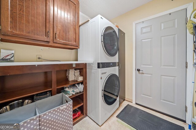 545 Matterhorn Way, Alpharetta, GA 30022 - laundry area featuring stacked washer / drying machine, cabinet space, and light tile patterned flooring