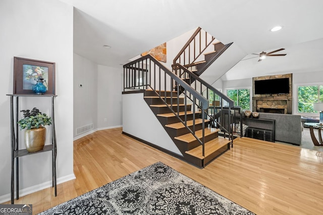 545 Matterhorn Way, Alpharetta, GA 30022 - stairway featuring wood finished floors, a fireplace, a ceiling fan, baseboards, and lofted ceiling