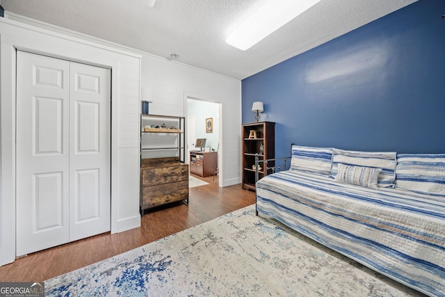 545 Matterhorn Way, Alpharetta, GA 30022 - bedroom featuring wood finished floors, a textured ceiling, a closet, and baseboards