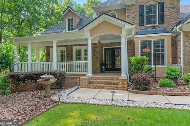 168 Eagle Pointe Dr, Dahlonega, GA 30533 - property entrance featuring french doors, roof with shingles, covered porch, brick siding, and stucco siding
