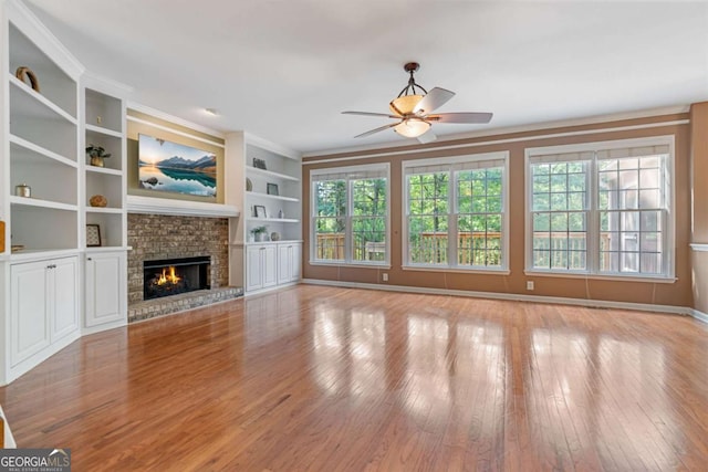 168 Eagle Pointe Dr, Dahlonega, GA 30533 - unfurnished living room featuring ceiling fan, hardwood / wood-style floors, a fireplace, and built in shelves
