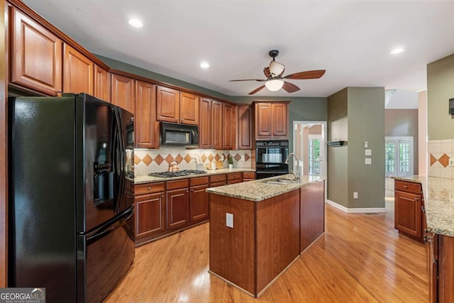 168 Eagle Pointe Dr, Dahlonega, GA 30533 - kitchen with black appliances, ceiling fan, tasteful backsplash, light wood-style flooring, and light stone counters