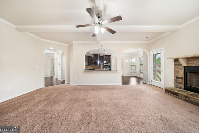 212 Jetta Cir, Mcdonough, GA 30253 - unfurnished living room featuring carpet, arched walkways, a stone fireplace, beamed ceiling, and ornamental molding