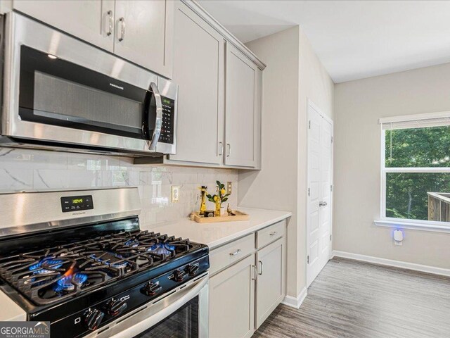 340 Louise Ln, Canton, GA 30114 - kitchen with stainless steel appliances, light wood-type flooring, tasteful backsplash, light countertops, and baseboards