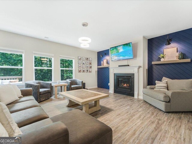 340 Louise Ln, Canton, GA 30114 - living room with plenty of natural light, a glass covered fireplace, wood finished floors, wood walls, and baseboards