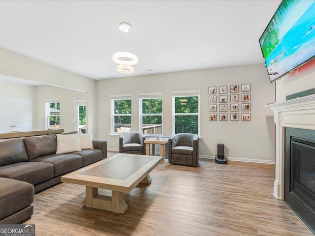 340 Louise Ln, Canton, GA 30114 - living room featuring wood finished floors, a glass covered fireplace, baseboards, and a chandelier