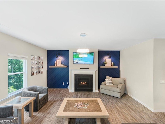 340 Louise Ln, Canton, GA 30114 - living area featuring an accent wall, a warm lit fireplace, wood finished floors, and baseboards
