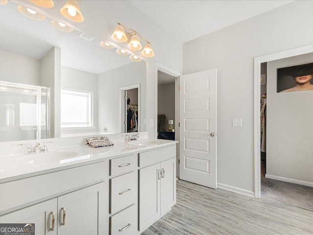 340 Louise Ln, Canton, GA 30114 - full bathroom featuring a spacious closet, double vanity, a shower stall, baseboards, and wood finished floors