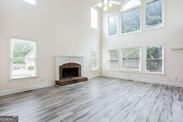 4045 Hillcrest View Ct, Suwanee, GA 30024 - unfurnished living room featuring a towering ceiling, a ceiling fan, wood finished floors, and baseboards
