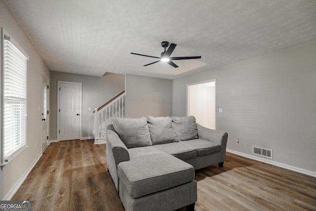 870 Rutherford Dr, Dacula, GA 30019 - living area featuring wood finished floors, ceiling fan, a textured ceiling, and stairway