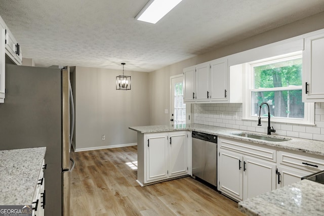 870 Rutherford Dr, Dacula, GA 30019 - kitchen with stainless steel appliances, a peninsula, tasteful backsplash, white cabinetry, and light wood-style flooring