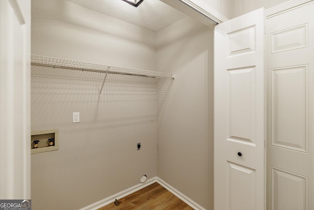 870 Rutherford Dr, Dacula, GA 30019 - laundry area featuring wood finished floors, hookup for a washing machine, a textured ceiling, and hookup for an electric dryer