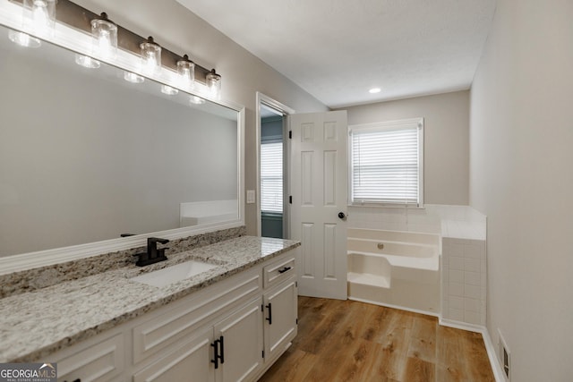 870 Rutherford Dr, Dacula, GA 30019 - full bath featuring vanity, a garden tub, and wood finished floors