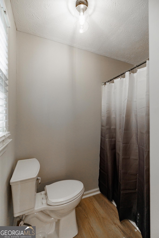 870 Rutherford Dr, Dacula, GA 30019 - full bathroom with wood finished floors, a shower with shower curtain, and a textured ceiling