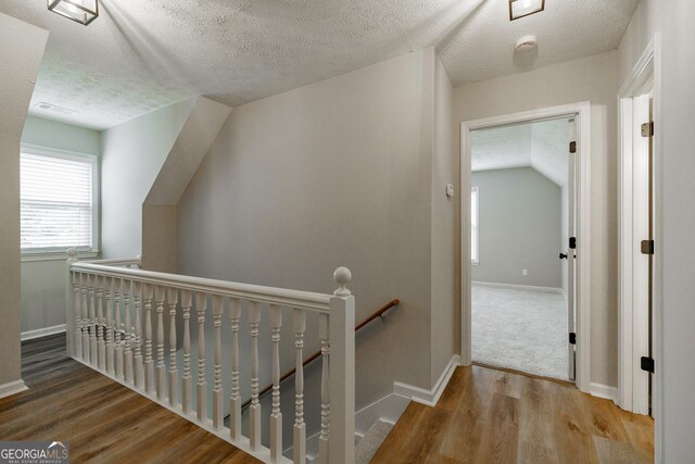 870 Rutherford Dr, Dacula, GA 30019 - corridor featuring an upstairs landing, a textured ceiling, wood finished floors, and lofted ceiling