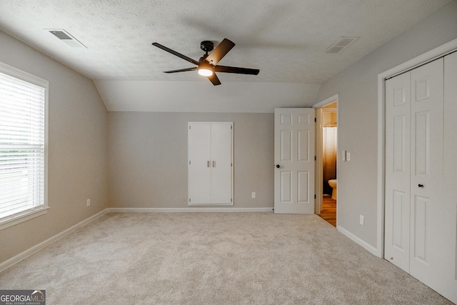 870 Rutherford Dr, Dacula, GA 30019 - unfurnished bedroom with multiple windows, carpet flooring, lofted ceiling, a closet, and a textured ceiling