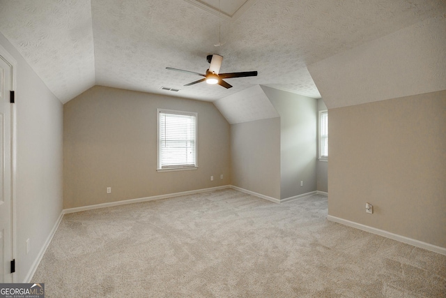 870 Rutherford Dr, Dacula, GA 30019 - bonus room featuring vaulted ceiling, a textured ceiling, light colored carpet, a ceiling fan, and attic access