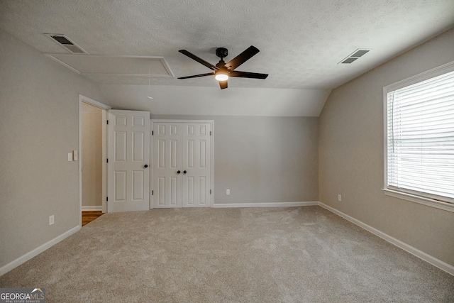 870 Rutherford Dr, Dacula, GA 30019 - unfurnished bedroom with attic access, multiple windows, a textured ceiling, carpet, and vaulted ceiling
