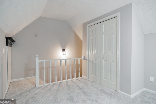 870 Rutherford Dr, Dacula, GA 30019 - additional living space with vaulted ceiling, carpet flooring, and a textured ceiling