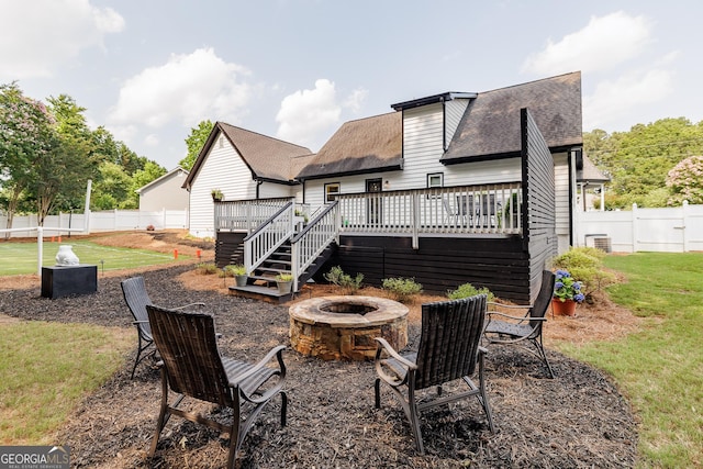 870 Rutherford Dr, Dacula, GA 30019 - back of property with a fire pit, roof with shingles, a deck, and a fenced backyard